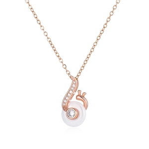 Macro view of rose gold musical melody snail pendant with white ceramic inlay and crystals