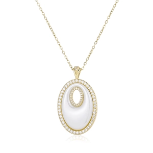 Détail d'un pendentif ovale doré avec incrustation blanche et pierres de zircon brillantes