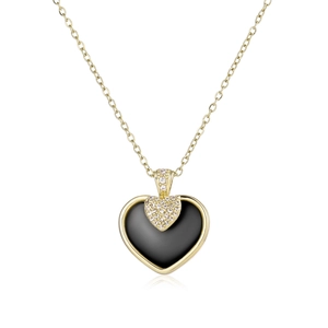 Détail d'un pendentif cœur en céramique avec incrustation noire et cristaux sur chaîne dorée