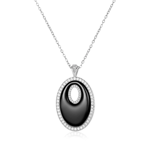 Détail macro d'un pendentif ovale argenté avec agate noire et sertissage de cristaux