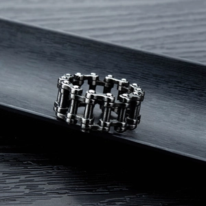 Detail view of a vintage silver bicycle chain ring with industrial punk aesthetic