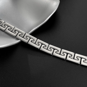 Detailed macro view of punk style stainless steel bracelet with Greek meander pattern