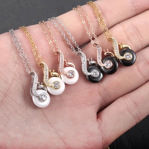 Detailed close-up of snail-shaped pendant necklaces with zircon inlay in six color variants