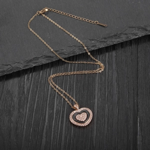 Detailed macro view of heart pendant necklace with rhinestones and black enamel finish