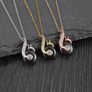 Three elegant snail-shaped necklaces with inlaid diamonds in silver, gold, and rose gold