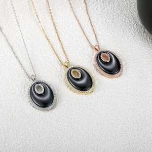 Ensemble de colliers pendentifs ovales évidés en or, argent et or rose avec pierres noires