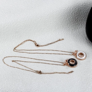 Detail of rose gold bow necklaces with ceramic circular pendants and pavé-set crystals