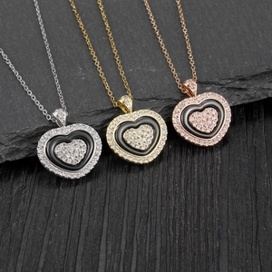 Macro shot of three-layer heart necklaces with sparkling zircons and black enamel inlay