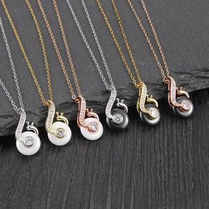 Elegant snail-shaped necklace pendants with pavé set accents and smooth stone shells