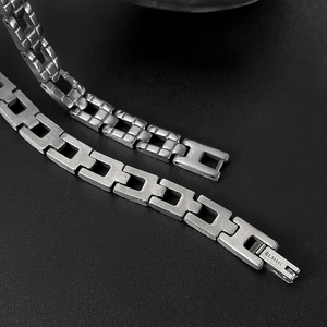 Détail macro du bracelet à maillons en acier inoxydable poli et brossé au style industriel