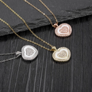 Detailed view of silver gold and rose gold heart necklaces with zircon pavé