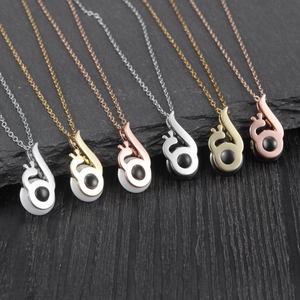 Detail of melody musical note pendants in silver gold and rose gold with black stones