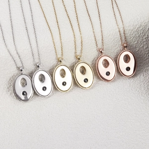 Vue détaillée de six colliers à pendentifs ovales creux en argent or et or rose élégants