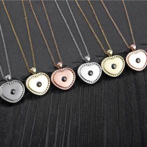 Macro shot of heart necklaces with micro-pave diamonds and central black bead in multiple colors