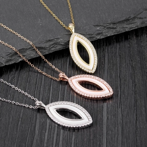 Trois colliers minimalistes en céramique marquise en or, or rose et argent sur pierre