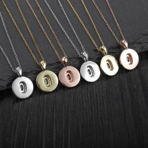 Detail showing seven O-shaped pendant necklaces in silver, gold, and rose gold finishes