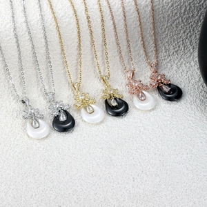 Détail de pendentifs en céramique goutte avec cristaux pavés en finitions or et argent