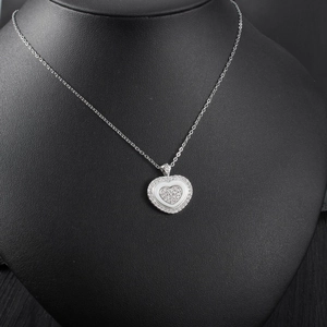 Detail of multi-layer heart pendant with sparkling crystals on elegant silver chain