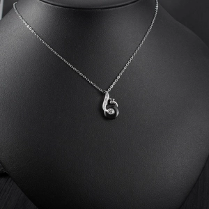Macro shot of silver music note pendant with black ceramic inlay and zircon stones