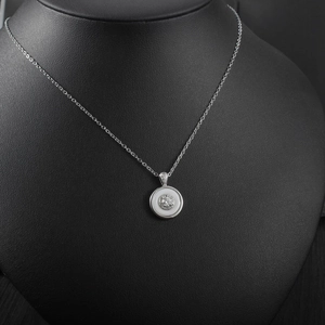 Detailed close-up of a luxury round pendant necklace with centered sparkling zircon stone