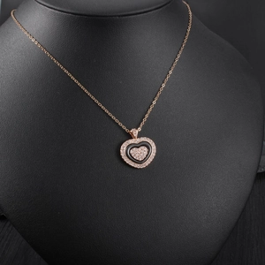 Detail of rose gold heart pendant with black inlay and crystals on a black bust