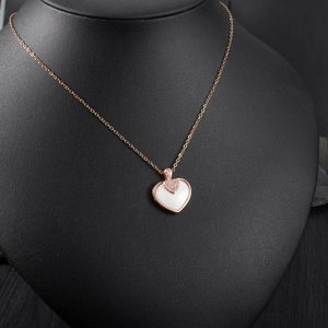 Gros plan du pendentif cœur en or rose avec céramique blanche et zircons étincelants