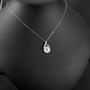 Close-up of melody note pendant with white stone and crystals on black neck bust