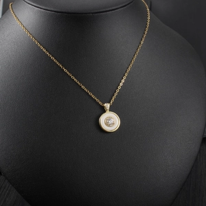 Close-up of elegant gold round necklace with diamond pendant on black neck model