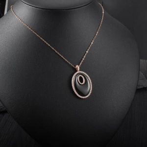 Détail du collier ovale en or rose avec pierre noire et double pavé de diamants