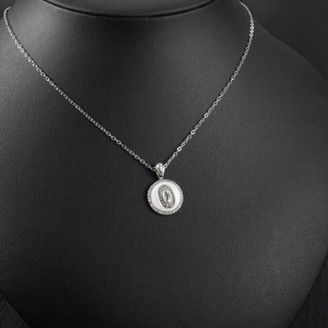 Detail showing round silver pendant with white inlay and sparkling cubic zirconia halo