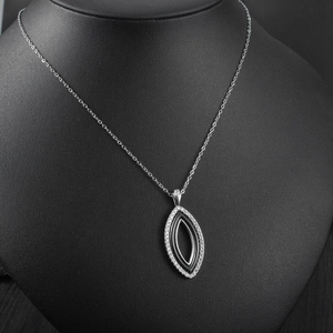 Détail d'un pendentif œil d'ange avec céramique noire et zircons brillants sur chaîne fine