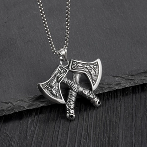 Close-up of double-headed battle axe pendant with Nordic bird relief and steel chain