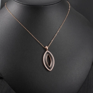 Détail du pendentif marquise en or rose avec céramique noire et cristaux blancs
