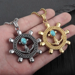 Details von Anker- und Ruderanhängern in Silber und Gold mit Türkis auf der Hand