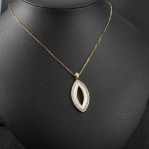 Détail d'un collier en or avec pendentif œil marquise sur un mannequin de cou noir