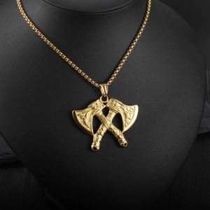 Detail of Viking double axe pendant in gold tone with intricate Nordic relief engraving