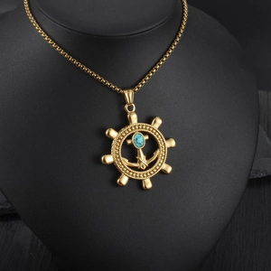 Detail eines nautischen Anker-Ruder-Anhängers in Gold mit eingelegtem Türkisstein