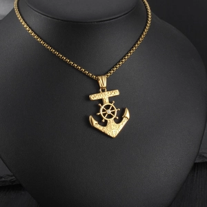 Dettaglio pendente ancora vintage oro con timone e cristallo su catena box chain