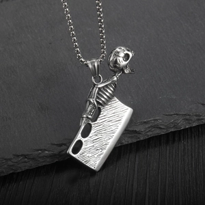 Gothic Totenkopf mit Metzgermesser-Anhänger in Silber auf rustikalem Felsenhintergrund