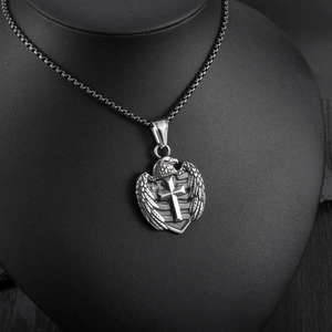 Detailed view of a vintage stainless steel shield pendant with eagle and cross on a neck bust