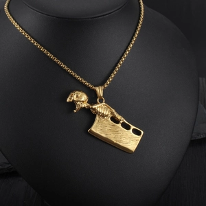 Detailansicht eines Gold-Totenkopfanhängers mit Hackbeil an einer Box-Halskette