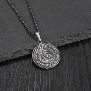 Vintage stainless steel Viking Celtic knot pendant necklace on dark stone background