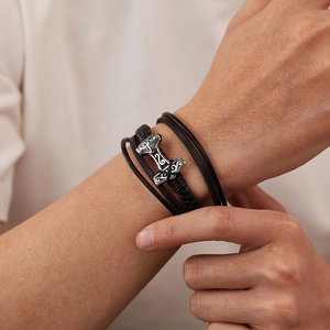Detail of vintage Mjolnir pendant on multi-layer braided black leather bracelet