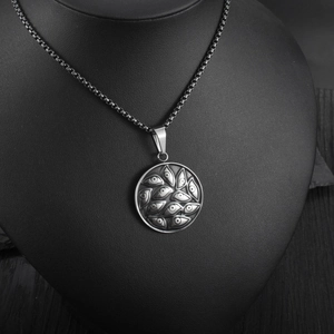 Macro detail of embossed evil eye pendant on a box chain for a vintage jewelry aesthetic