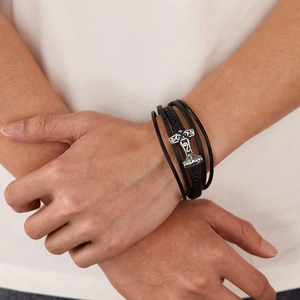 Detail of Thor Mjolnir pendant on multi-layer braided leather bracelet for men