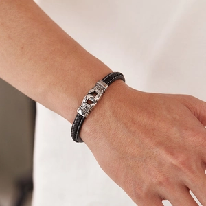 Vue macro d'un bracelet en cuir tressé noir avec fermoir gravé en argent vintage