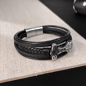Detail of multi-layer black braided leather bracelet with silver Thor Hammer charm
