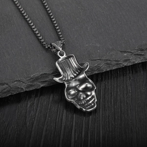 Pendentif crâne gothique avec haut-de-forme et chaîne box en acier sur pierre sombre