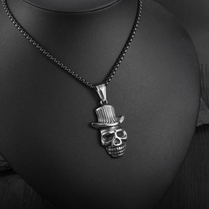 Gros plan d'un pendentif crâne gothique avec haut-de-forme sur buste à bijoux noir