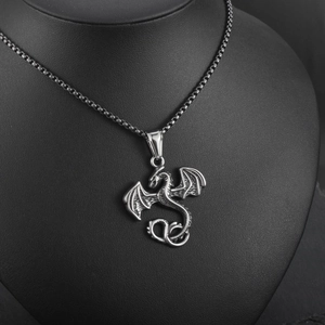 Vue détaillée du pendentif dragon argenté vintage avec des textures d'ailes précises